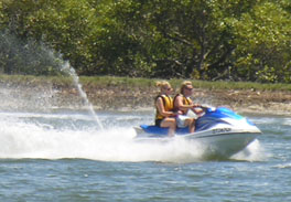 A man and a woman riding on a jetski in the water